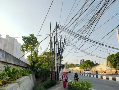 Instalasi kabel menjuntai yang berada di sekitar Jalan Gunung Sahari, Mangga Dua, Jakarta, Kamis (10/7/2019). Buruknya tata instalasi kabel di Ibu Kota menjadi penyebab banyaknya kabel semrawut, meskipun kondisi itu berbahaya serta mengganggu pemandangan. (Liputan6.com/Immanuel Antonius)