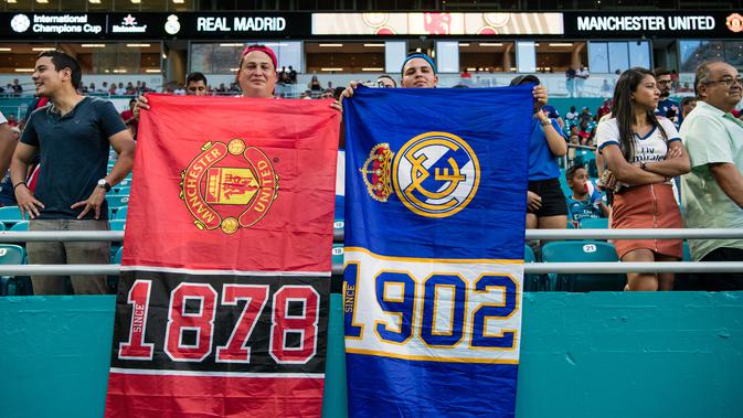 Suporter Manchester United dan Real Madrid membentangkan spanduk saat menyaksikan tim kesayangannya bertanding pada ICC 2018 di Miami Gardens, Fla (31/7). MU menang tipis 2-1 atas Madrid. (AFP Photo/Rob Foldy)