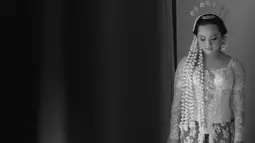 Rachel Amanda mengenakan kebaya adat Jawa bernuansa putih yang dirancang oleh Mutiara Meddyan di momen akad nikah. Dipadukan dengan kain batik sidomukti yang bermakna agar calon pengantin mendapat kemakmuran dan masa depan yang lebih baik setelah berumah tangga.(Liputan6.com/IG/@hibikiwedding)