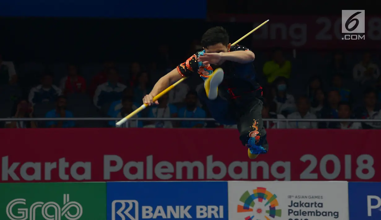 Atlet Wushu Indonesia Hulaefi Achmad beraksi pada laga final Men's Daoshu dan Gunshu Asian Games 2018 di JIexpo,Hall B, Kemayoran, Jakarta, Selasa (21/8). Achmad berhasil meraih perunggu dan sukses merebut total 19,41 poin. (Merdeka.com/Imam Buhori)
