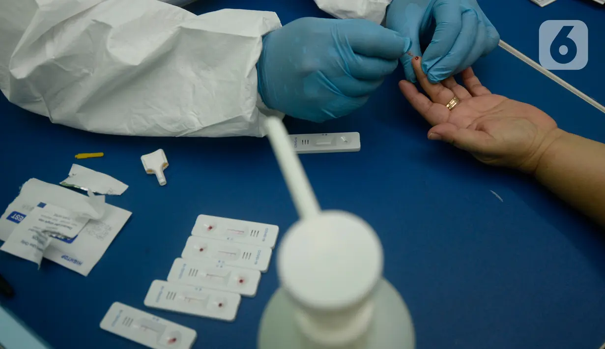 Petugas melakukan pemeriksaan cepat COVID-19 (Rapid Test) kepada tenaga pendidik SMP di SMPN 3 Ciputat, Tangerang Selatan, Kamis (27/08/2020). Rapid tes yang diikuti 400 guru mencakupi wilayah Ciputat dan Ciputat Timur itu untuk mencegah penyebaran Covid-19 di lingkungan pendidikan. (merdeka.com/Dwi