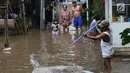 Warga membersihkan banjir yang menggenangi kawasan Cilandak Timur, Jakarta Selatan, Selasa (22/1). Hujan deras yang mengguyur Jakarta dan sekitarnya sejak pagi menyebabkan banjir di sejumlah sudut Ibu Kota. (Liputan6.com/Immanuel Antonius)