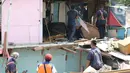 Sejumlah petugas gabungan dari Satpol PP, KAI dan Polisi membongkar bangunan lokalisasi liar Gunung Antang di Matraman, Jakarta Timur, Selasa (30/8/2022). Satu unit ekskavator diturunkan untuk membantu proses pembongkaran lokalisasi liar itu. (Liputan6.com/Herman Zakharia)