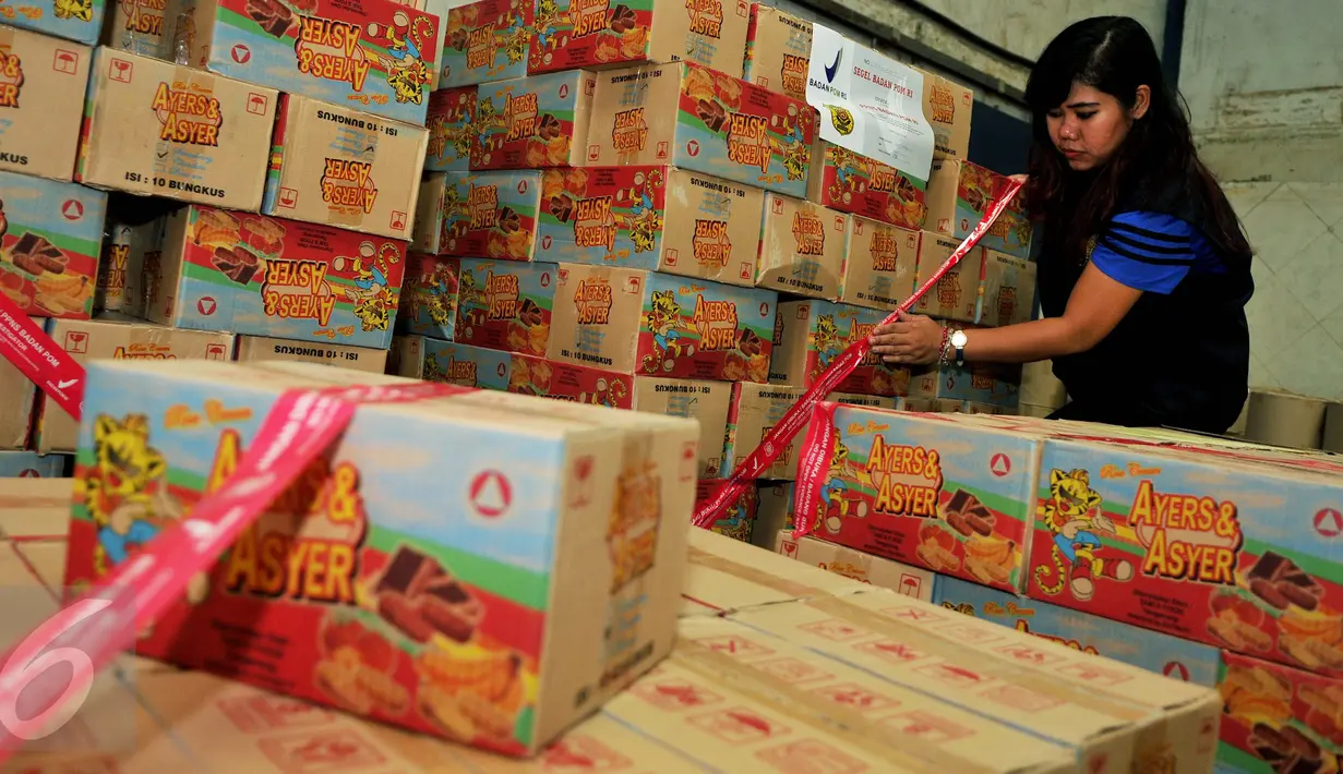 Petugas menyegel sejumlah kardus makanan siap edar saat penggerebekan pabrik makanan ringan ilegal oleh BPOM di Kota Tangerang, Kamis (4/8). Ada 7.000 kardus berhasil diamankan petugas dengan kerugian Rp 400 juta. (Liputan6.com/Gempur M Surya)