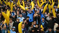 Suporter Manchester City mengibarkan pisang tiup di tribun menjelang pertandingan Liga Inggris melawan Ipswich Town di Stadion Etihad, Manchester, Sabtu (17/10/2026). (Oli Scarff/AFP)