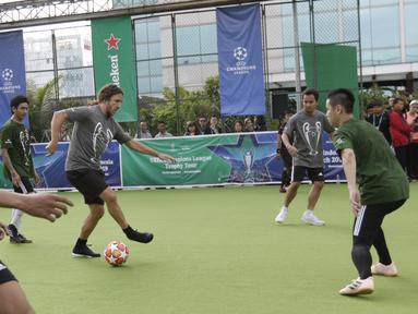 Legenda Barcelona, Carles Puyol, menggiring bola saat bermain futsal di Lapangan Menara Imperium, Jakarta, Selasa (12/3). Pertandingan tersebut merupakan bagian dari kegiatan UEFA Champions League Trophy Tour di Jakarta. (Bola.com/M Iqbal Ichsan)