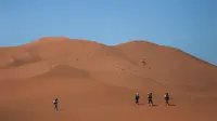 Peserta melintasi bukit pasir saat mengikuti kompetisi Marathon des Sables ke-33 di gurun Sahara, Maroko (14/4). Sekitar 1.000 peserta dari 50 negara ikut berkompetisi dalam Marathon des Sables ini. (AP Photo / Mosa'ab Elshamy)