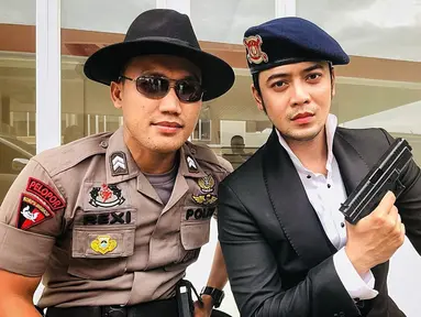 Kriss Hatta berpose dengan seorang polisi dalam sebuah acara. Ia memegang handgun. (Foto: Instagram/@krisshatta07)