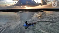 Wisatawan berenang di kolam renang alami yang terbentuk saat air laut surut di kawasan Pantai Suluban, Uluwatu, Bali, Selasa (7/9/2021). Keunikan Pantai Suluban dengan kolam-kolam yang terbentuk di atas karang menjadi daya tarik wisatawan. (merdeka.com/Arie Basuki)