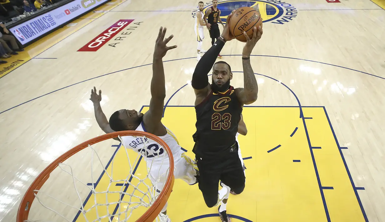 Pemain Cavaliers, LeBron James (kanan) mencoba mencetak poin saat diadang pemain Warriors, Draymond Green pada gim pertama final NBA basketball di Oakland, California, (31/5/2018). Warriors menang 124-114. (Ezra Shaw/Pool Photo via AP)