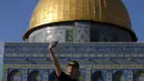 Ammer Ali (17) berfoto selfi saat berkunjung ke kubah Ash-Shakhrah di area Masjid Al-Aqsa, Yerusalem, 29 Juni 2015. (REUTERS/Ammar Awad) 