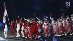 Parade atlet Indonesia saat upacara Penutupan Asian Games 2018 di Stadion Utama Gelora Bung Karno, Jakarta, Minggu (2/9). Mereka mengenakan jas hujan yang mengguyur Jakarta. (Liputan6.com/Helmi Fithriansyah)