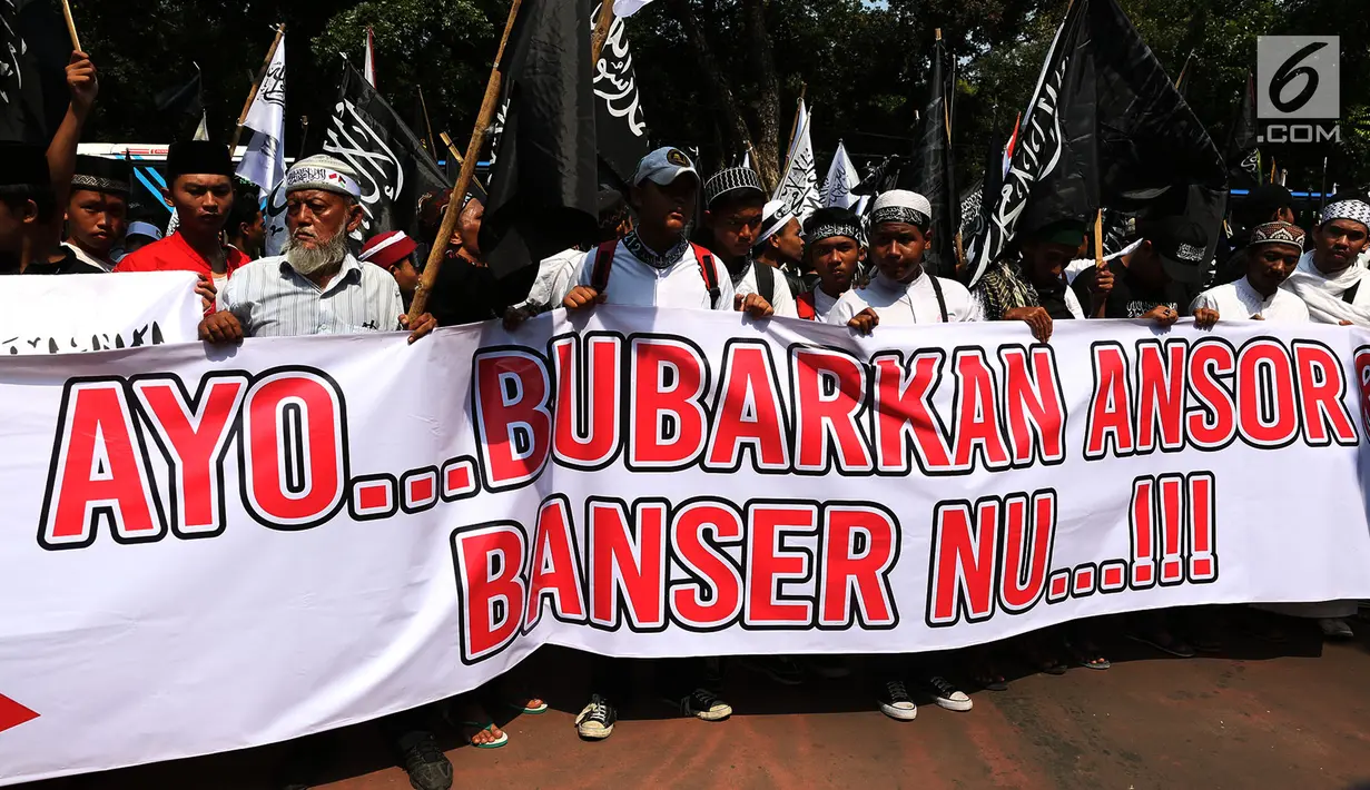 Massa Aksi Bela Tauhid membentangkan spanduk berisi tuntutan di depan Gedung Kemenko Polhukam, Jakarta, Jumat (26/10). Aksi ini mengkibatkan sejumlah ruas jalan mengalami kemacetan. (Merdeka.com/Imam Buhori)