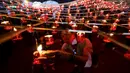 Warga menyalakan lilin sebelum melepaskan lampion buatan tradisional ke langit selama festival tahunan Tazaungdaing di Taunggyi, Myanmar (19/11). (REUTERS/Soe Zeya Tun)