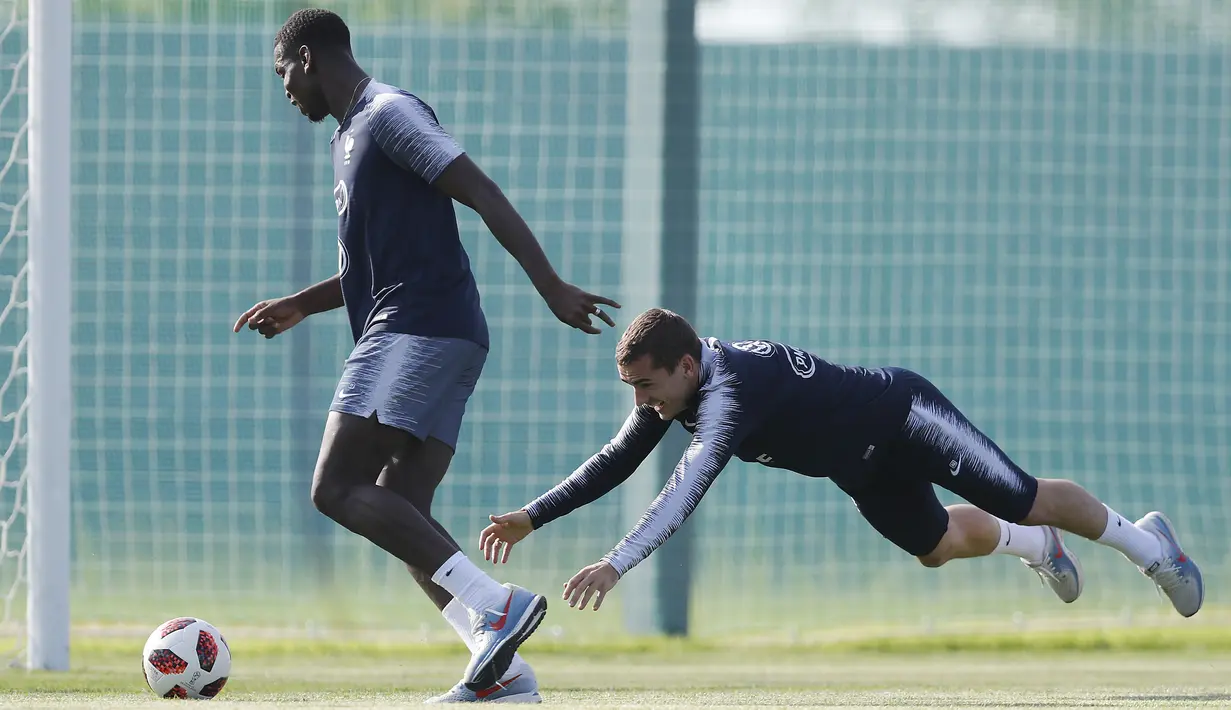 Paul Pogba (kiri) mengecoh Antoine Griezmann saat sesi latihan di Glebovets, Rusia, (12/7/2018). Latihan tersebut sebagai persiapan Prancis melawan Kroasia pada Final Piala Dunia 2018. (AP/David Vincent)