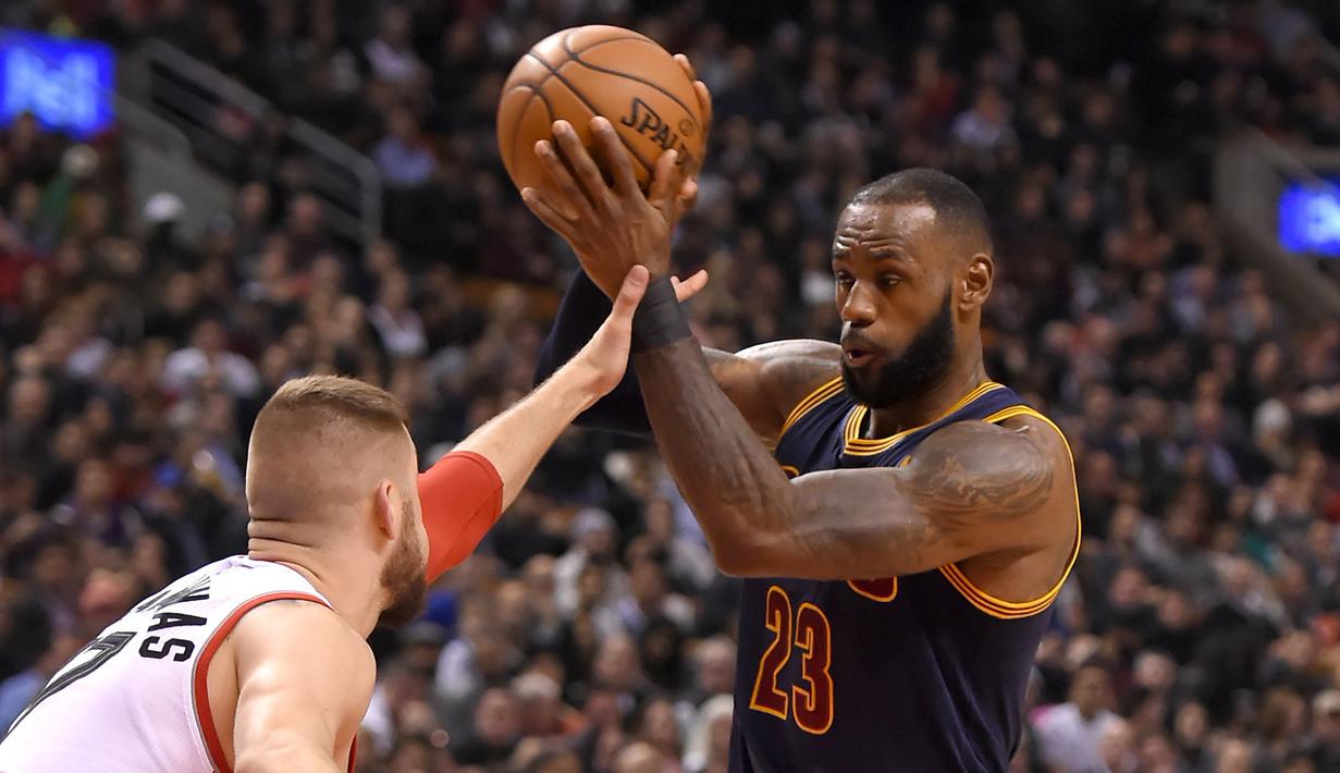Pemain Cleveland Cavaliers, LeBron James #23 berusaha melewati hadangan pemain Raptors, Jonas Valanciunas #17 pada laga NBA di Air Canada Centre, (6/12/2016). (Reuters/Dan Hamilton-USA TODAY Sports)
