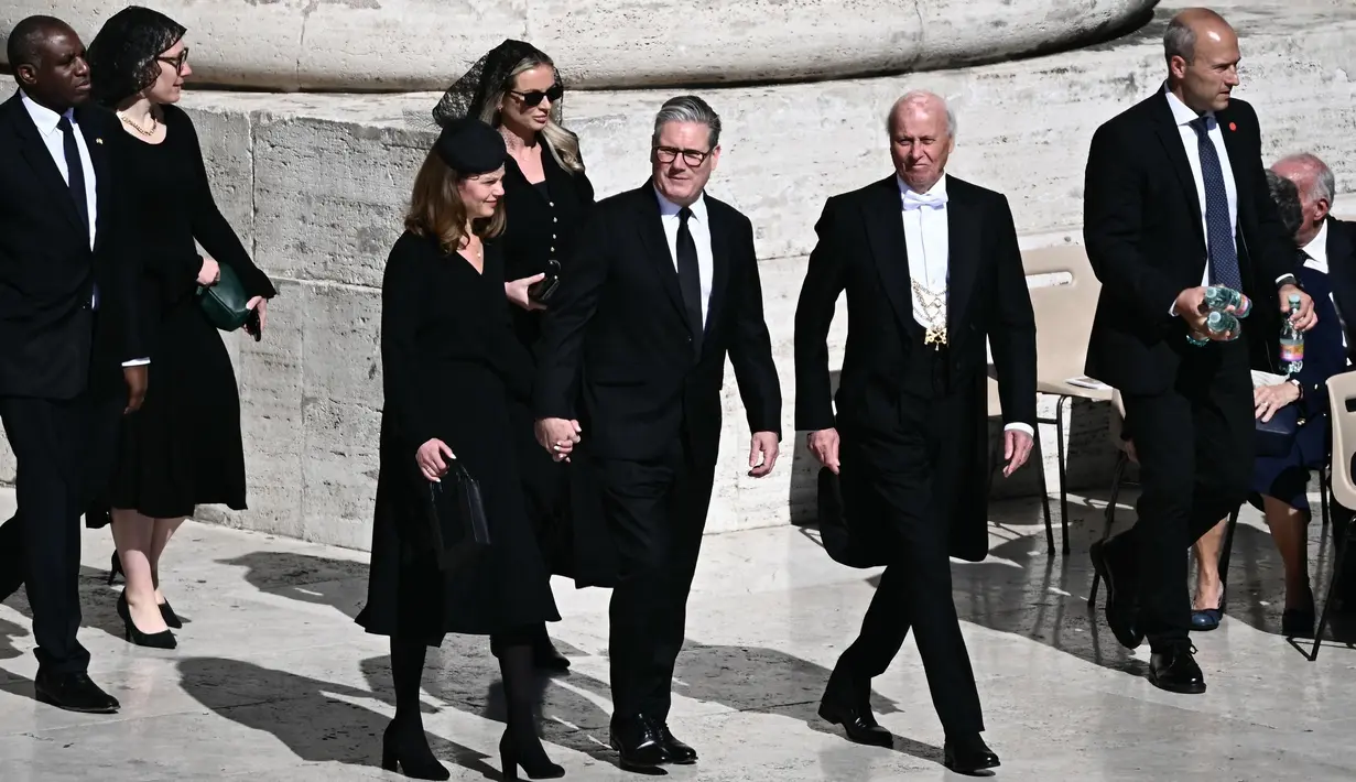 Perdana Menteri Inggris Keir Starmer (tengah) dan istrinya Victoria Starmer bersama Menteri Luar Negeri Inggris David Lammy (kiri) tiba menjelang upacara pemakaman mendiang Paus Fransiskus di Lapangan Santo Petrus, Vatikan, 26 April 2025. (Filippo MONTEFORTE/AFP)