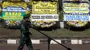 Prajurit TNI melintas di depan karangan bunga tanda duka cita atas meninggalnya mantan KSAD Jenderal TNI (Purn) Pramono Edhie Wibowo di kawasan Puri Cikeas, Kab Bogor, Jabar, Minggu (14/6/2020). Pramono Edhie Wibowo wafat di usia 65 tahun akibat serangan jantung. (Liputan6.com/Helmi Fithriansyah)