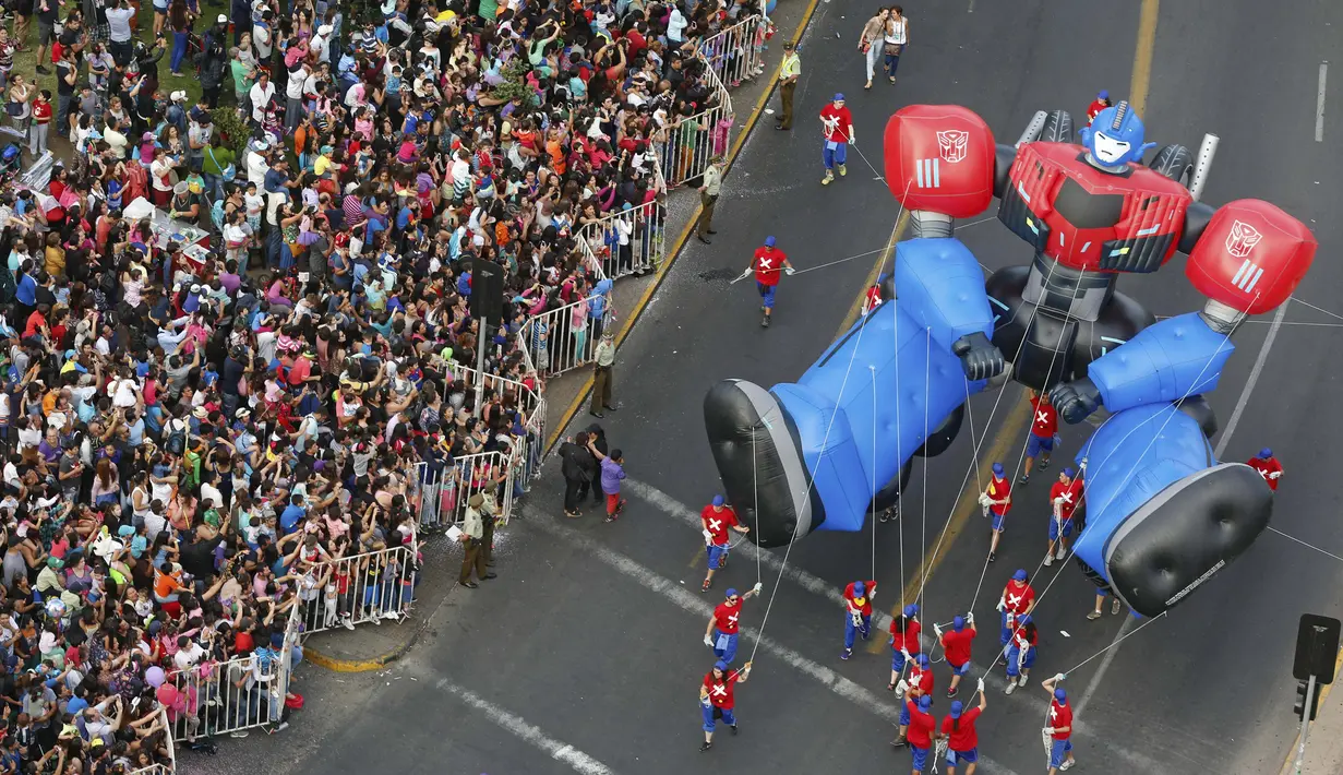 Parade balon karakter kartun meramaikan jalanan kota Santiago di Chile, (13/12). Selain parade balon ada juga parade kendaraan yang dihias unik. (REUTERS/Pablo Sanhueza)