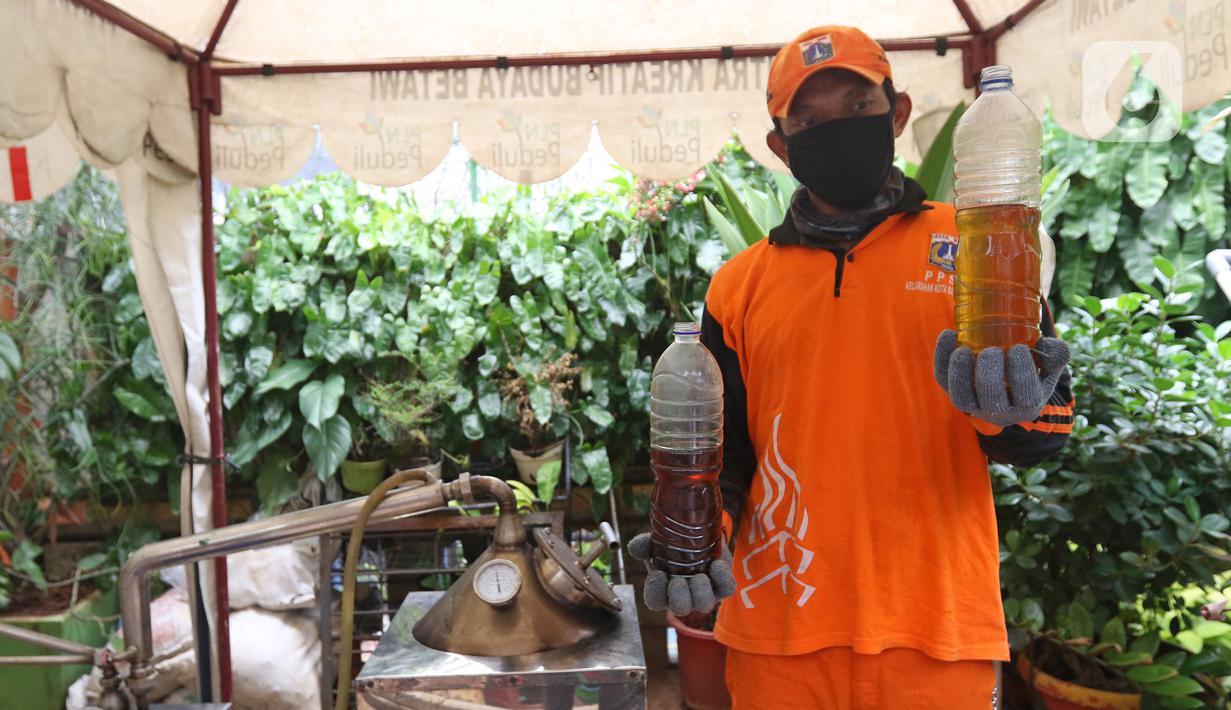 Petugas PPSU Kelurahan Kota Bambu Selatan menunjukkan solar hasil olahan dari sampah plastik di Bank Sampah Hasil Berkah, Jakarta, Kamis (11/11/2021). Sampah plastik dikonversi menjadi solar menggunakan alat mesin pirolisis untuk mengurangi pencemaran lingkungan. (Liputan6.com/Herman Zakharia)