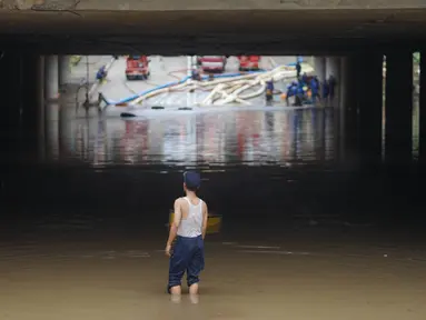 Petugas berdiri di antara banjir yang menggenangi underpass Kemayoran, Jakarta, Senin (3/2/2020). Curah hujan tinggi menyebabkan banjir yang menggenangi kawasan tersebut lama surut sehingga menutup arus lalu lintas. (Liputan6.com/Immanuel Antonius)