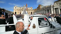 Menaiki kendaraan kepausan "popemobile", Paus Leo XIV menyapa puluhan ribu umat yang hadir di Lapangan Santo Petrus, Basilika, Vatikan, untuk menyaksikan pelantikannya pada Minggu, 18 Mei 2025. (Andreas SOLARO/AFP)