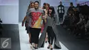 Desainer Ivan Gunawan bersama penyanyi Titi DJ berjalan saat membawakan busana bertema lembayoeng di Jakarta Fashion Week (JFW) 2016, Jakarta Fashion Week (JFW) 2016, Senayan city, Jakarta, (25/10/2015). (Liputan6.com/Herman Zakharia)