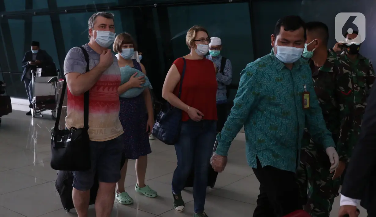 Sejumlah Warga Negara Asing (WNA) diarahkan untuk karantina menuju hotel saat tiba di Bandara Soekarno Hatta, Tangerang, Selasa (29/12/2020). Pemerintah Indonesia melarang masuk WNA dari semua negara mulai 1 hingga 14 Januari 2021 menyusul varian baru COVID-19. (Liputan6.com/Angga Yuniar)