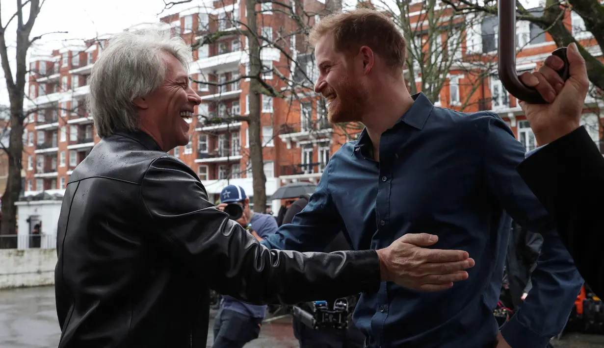 Pangeran Harry (kiri) berbincang dengan penyanyi AS, Jon Bon Jovi setibanya di Abbey Road Studios, London, Jumat (28/2/2020). Pentolan Bon Jovi dan Pangeran Harry akan bertemu dengan paduan suara Invictus Games untuk merekam lagu untuk amal. (AP/Kirsty Wigglesworth)