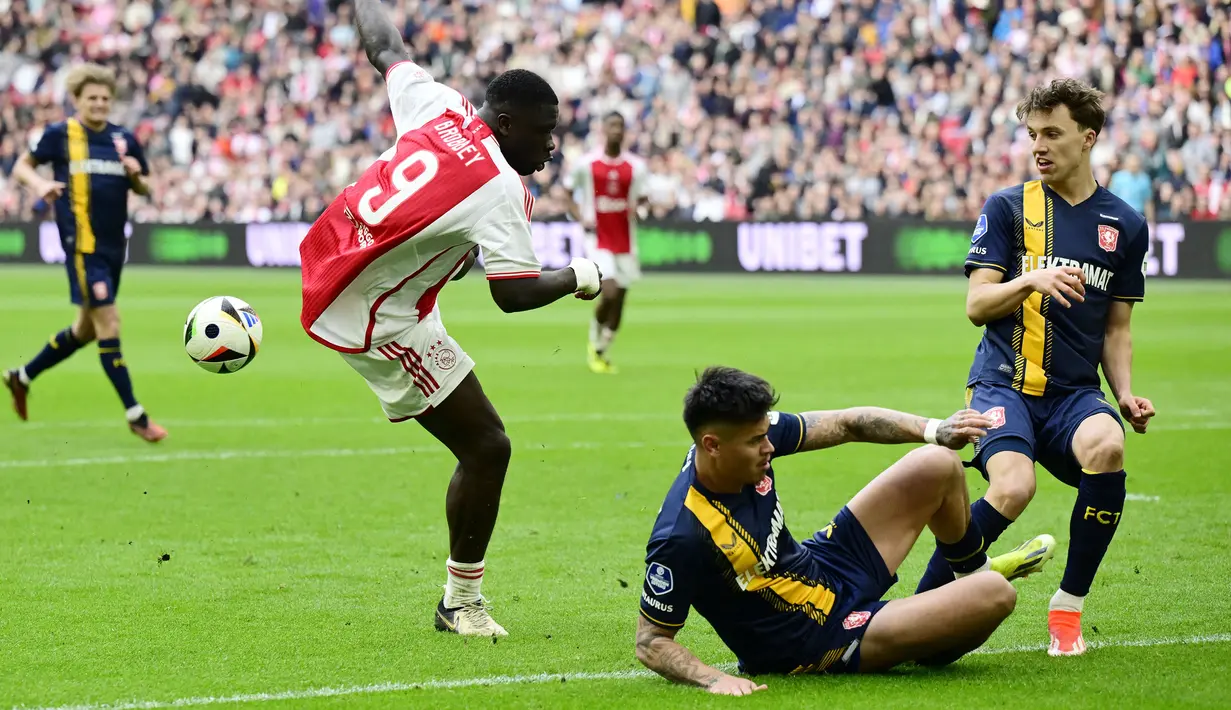 Pemain Twente, Mees Hilgers (tengah kanan) menghalau bola tendangan pemain Ajax Amsterdam, Brian Brobbey pada laga lanjutan Liga Belanda 2023/2024 di Johan Cruijff ArenA, Amsterdam, Belanda 14 April 2024. (AFP/ANP/Olaf Kraak)