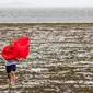 Wisatawan berjalan di perairan Teluk Tampa yang surut karena air surut dan angin kencang dari Badai Ian di Tampa, Florida, Amerika Serikat, 28 September 2022. (Willie J. Allen Jr./Orlando Sentinel via AP)