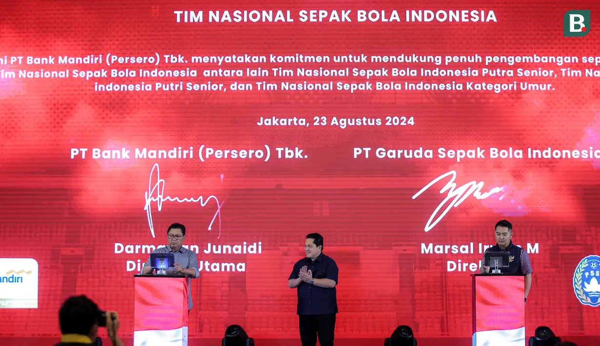 <p>Ketua Umum PSSI, Erick Thohir (tengah) menyaksikan penandatanganan penandatanganan kerjasama yang dilakukan oleh Direktur Utama Bank Mandiri, Darmawan Junaidi (kiri) dan Direktur PT Garuda Sepak Bola Indonesia (GSI), Marsal Masita di Plaza Mandiri, Senayan, Jakarta, Jumat (23/08/2024). (Bola.com/Bagaskara Lazuardi)</p>