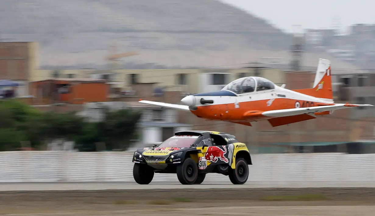 Pereli asal Prancis, Sebastien Loeb saat balapan dengan pesawat Angkatan Udara Peru (FAP) di Lima, Peru (6/1). Dengan mengendarai Peugeot 3008, Sebastien Loeb melesat meninggalkan si burung besi tersebut. (AP Photo/Ricardo Mazalan)