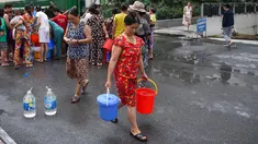Warga membawa wadah berisi air usai mengisinya dari truk tangki pasokan pemerintah di Hanoi, Vietnam, Kamis (17/10/2019). Pemerintah memberi bantuan air bersih setelah zat penyebab kanker karsinogen mencemari air ledeng beberapa daerah di Hanoi. (Nhac NGUYEN/AFP)