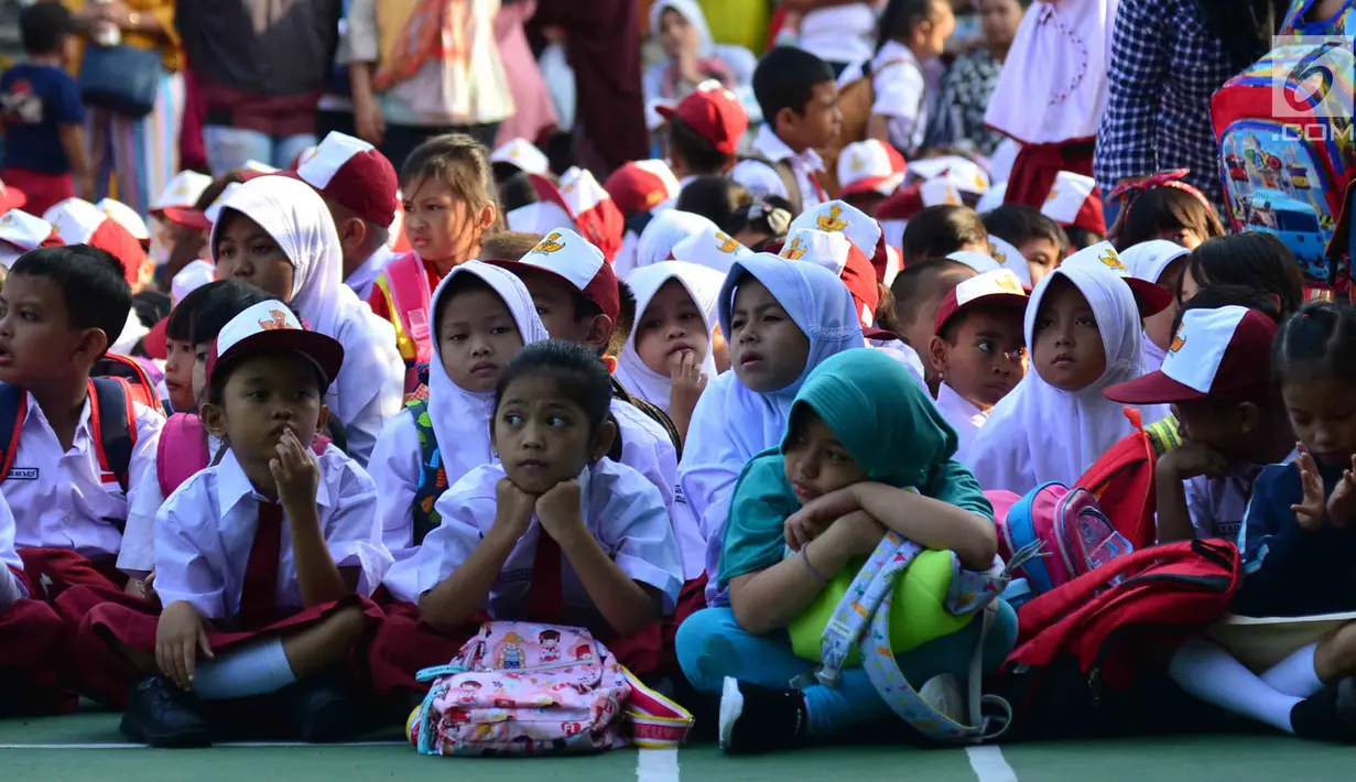 Murid-murid sekolah dasar duduk di halaman sekolah SDN 03, Pesanggrahan, Jakarta Selatan, Senin (16/7). Hari ini merupakan hari pertama masuk sekolah bagi para siswa dari jenjang TK hingga SMA untuk tahun ajaran 2018-2019. (Merdeka.com/Arie Basuki)
