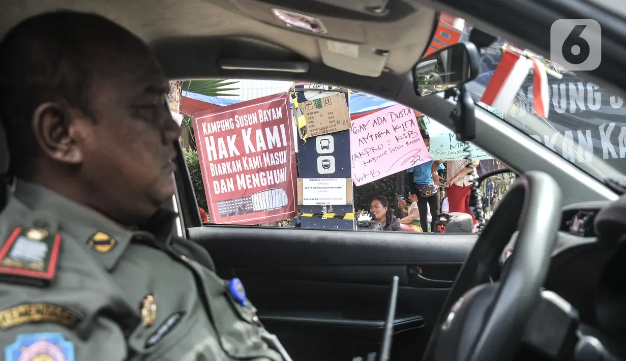 Petugas Satpol PP berjaga saat warga gusuran Kampung Bayam menggelar aksi di depan Balai Kota, Jakarta, Senin (5/12/2022). Nasib warga Kampung Bayam di kawasan Jakarta International Stadium (JIS), Jakarta Utara, kian merana. Meski sudah diresmikan Gubernur DKI Jakarta Anies Baswedan pada 12 Oktober 2022,  sampai saat ini mereka belum bisa menghuni gedung empat lantai tersebut. (merdeka.com/Iqbal S. Nugroho)