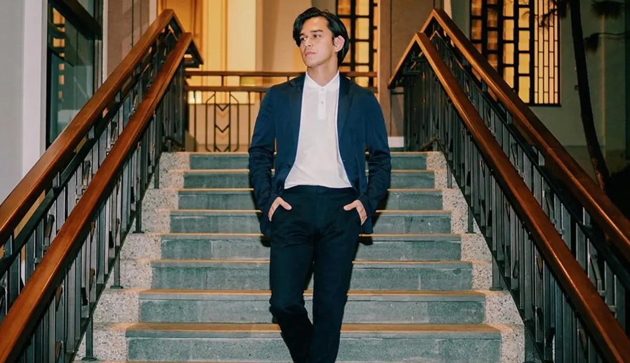 Tak hanya lihai dalam bermain peran, pria kelahiran 1989 ini juga pandai dalam memadukan busana. Salah satunya busana casual. Menggunakan outer berwarna navy dan rambut belah samping, penampilan simpel ala Rangga terlihat menawan. (Liputan6.com/IG/@azofrangga)