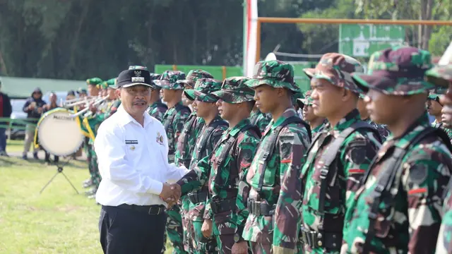 Pj Bupati Garut, Barnas Adjidin menyalami prajurit TNI dalam apel pembukaan program TMMD Reguler Kodim 0611/Garut Ke 120 Tahun Anggaran 2024 di Desa Cintadamai, Kecamatan Sukaresmi, Kabupaten Garut, Jawa Barat. (Liputan6.com/Jayadi Supriadin)