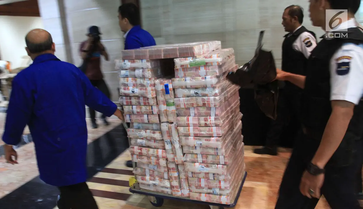 Pegawai Bank Mandiri membawa uang ganti rugi korupsi BLBI dengan terpidana Samadikun Hartono di Gedung Bank Mandiri, Jakarta, Kamis (17/5). Samadikun berhasil dipulangkan dari Shanghai ke Indonesia setelah 13 tahun buron. (Liputan6.com/Angga Yuniar)