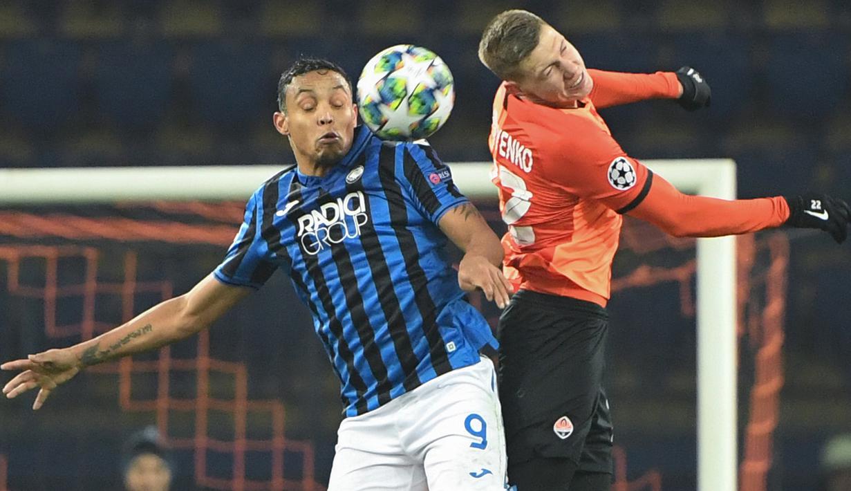 Pemain Atalanta Luis Muriel dan pemain Ukraina Shakhtar Donetsk Mykola Matviyenko berebut bola pada pertandingan Grup C Liga Champions di Kharkiv, Ukraina, Rabu (11/12/2019). Atalanta sukses mengukir sejarah untuk pertama kalinya mampu lolos ke babak 16 besar Liga Champions. (Sergei SUPINSKY/AFP)