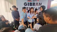 Calon wakil presiden (cawapres) nomor urut 2, Gibran Rakabuming Raka membagi-bagikan susu kepada anak-anak dan ibu-ibu di Kelurahan Poris Gaga, Tangerang, Banten, Senin (4/12/2023)&nbsp;dengan didampingi sang istri, Selvi Ananda. (Liputan6.com/Lizsa Egeham)