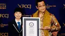 Penyanyi dan penulis lagu asal Jepang, Piko Taro menunjukan sertifikat dari Guinness World Records di Club of Japan, Tokyo (28/10).  Pikotaro meraih Guinness World Records untuk lagu terpendek yang masuk di Billboard Hot 100. (Reuters/Issei Kato)