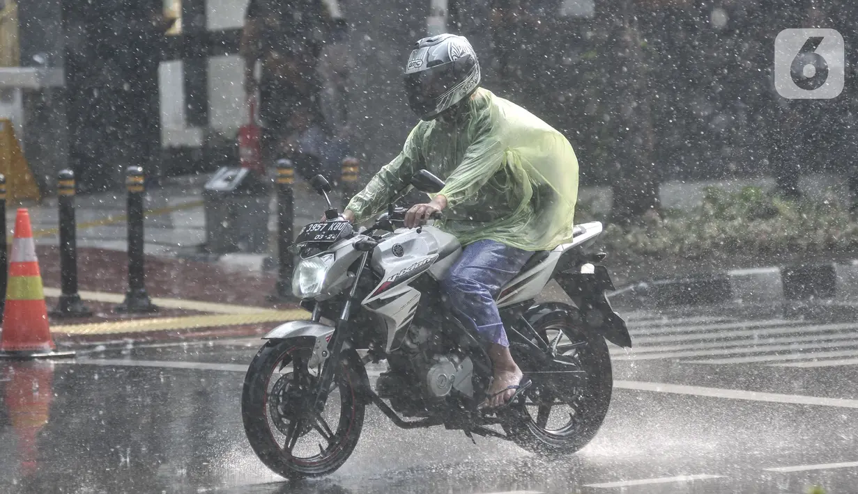 Pengendara motor mengenakan jas pelindung saat hujan mengguyur kawasan Monas, Jakarta Pusat, Kamis (5/1/2023). Warga diharapkan waspada serta mempersiapkan diri dengan perubahan cuaca yang akan terjadi selama satu pekan ke depan. (merdeka.com/Iqbal S Nugroho)