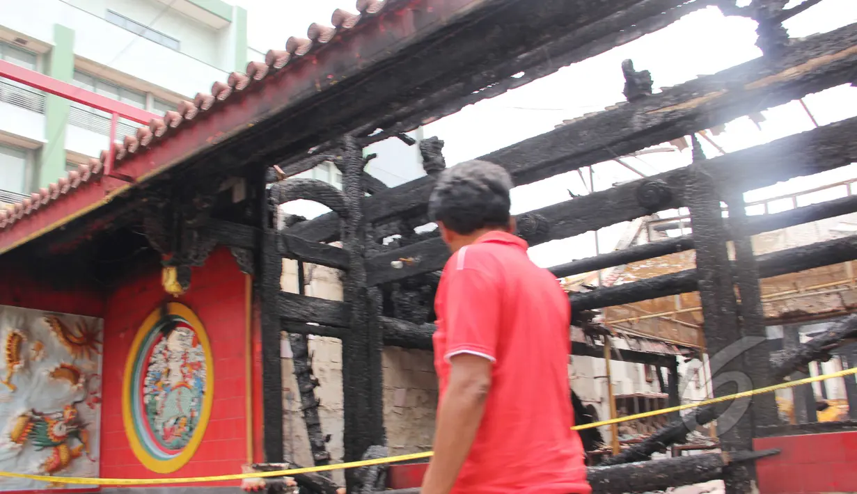 Warga melintas di depan Wihara Dharma Bakti yang masih dipasangi garis polisi, Kamis (19/3/2015). Wihara yang lebih dikenal dengan Petak Sembilan ini terbakar pada 2 Maret 2015 lalu. (Liputan6.com/Helmi Afandi)