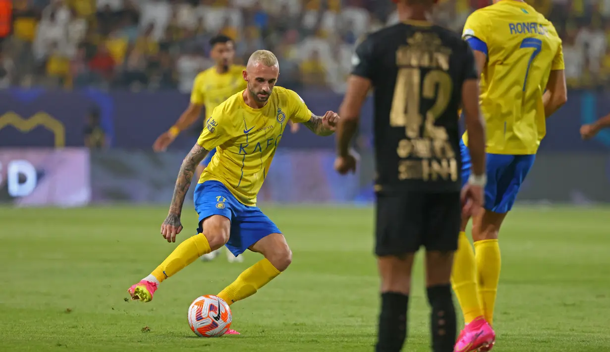 Pemain Al Nassr, Marcelo Brozovic (kiri), berusaha mencari celah untuk melewati hadangan pemain Al Taawon dalam laga pekan ke-2 Liga Arab Saudi 2023/2024 yang berlangsung di KSU Football Stadium, Sabtu (19/8/2023) dini hari WIB. (AFP/Fayez Nureldine)