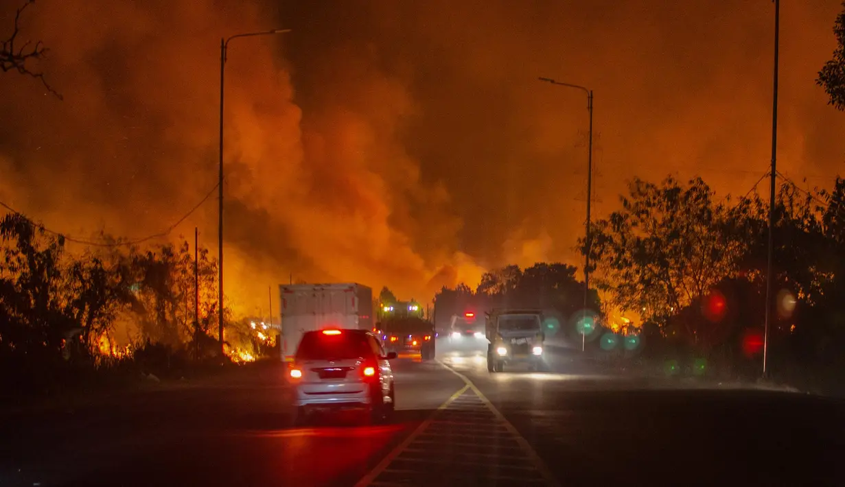 Kobaran api sangat besar hingga menyebabkan kepulan asap tebal yang menyelimuti jalan. (Al ZULKIFLI/AFP)