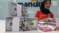 Teller tengah menghitung mata uang rupiah dan dolar di Bank Mandiri, Jakarta, Kamis (10/1). Hingga hari ini, US$ 1 dibanderol Rp 14.020. Rupiah menguat 0,71% dibandingkan posisi penutupan perdagangan hari sebelumnya. (Liputan6.com/Angga Yuniar)
