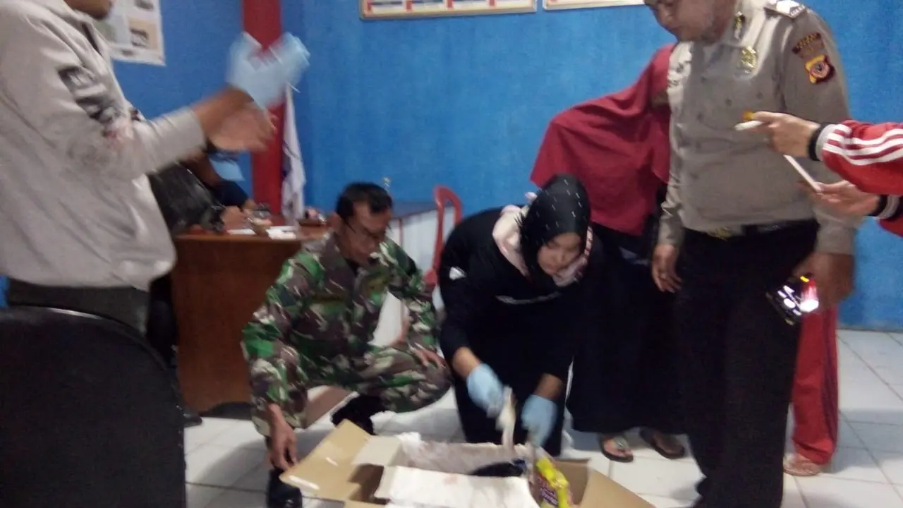 Nampak beberapa anggota polsek dan koramil Cikajang membuka tas mencurigakan berisi jenazah bayi perempuan