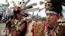 Seorang warga Suku Dayak Landak menngoperasikan kameranya saat festival Karnaval Katulistiwa di Pontianak, Kalimantan Barat, Sabtu (22/8/2015). (Liputan6.com/Faizal Fanani)