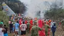 Pihak berwenang setempat melaporkan, sedikitnya delapan orang tewas dan puluhan lainnya luka-luka dalam kecelakaan itu. Tampak dalam foto, orang-orang berdiri di sekitar pesawat kargo militer yang jatuh setelah lepas landas dari Puerto Leguizamo, Kolombia, sebuah kotamadya terpencil di provinsi Amazon Putumayo, Senin, 23 Maret 2026. (MiPutumayo via AP)